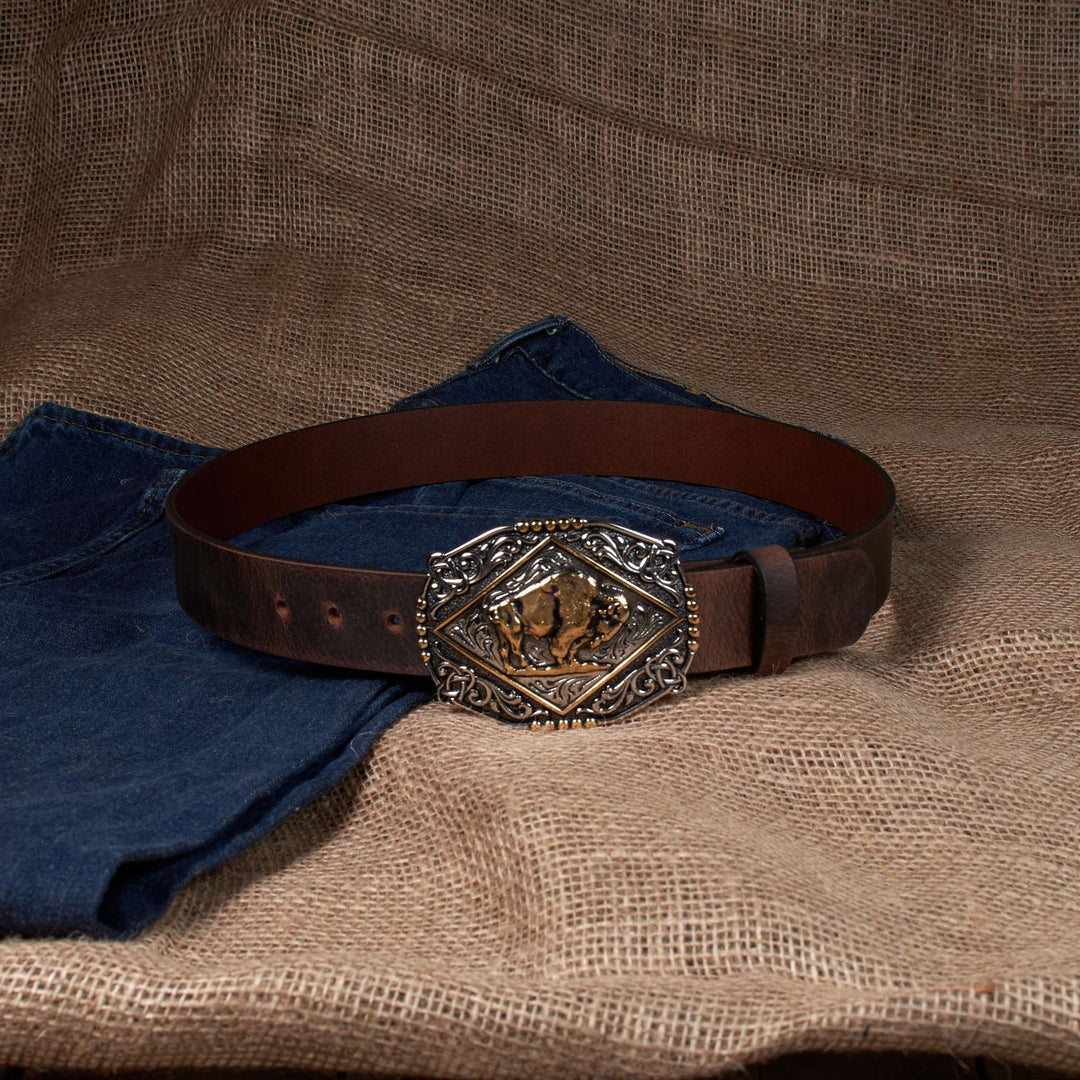 Brown leather belt with decorative buckle on a textured fabric background