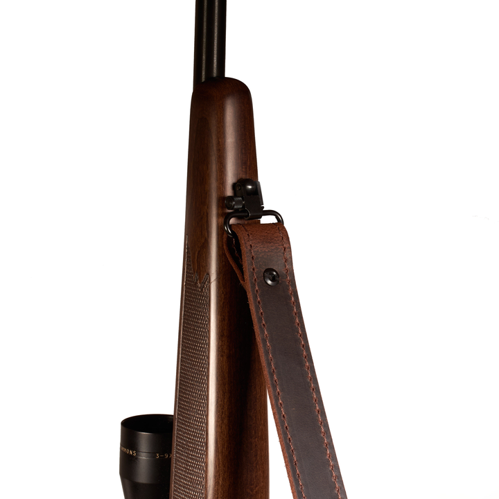 Brown leather rifle stock with a black scope on a white background