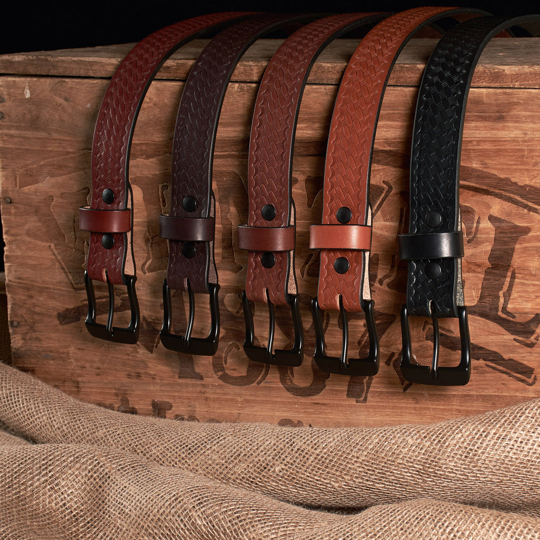 Set of leather belts with different colors on a wooden surface