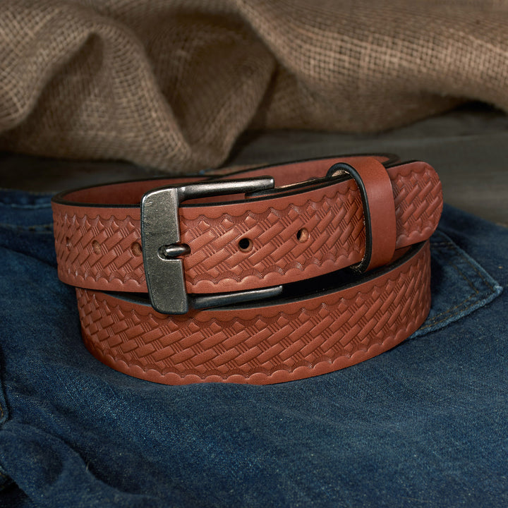 Brown basketweave leather belt with a silver buckle on blue jeans.