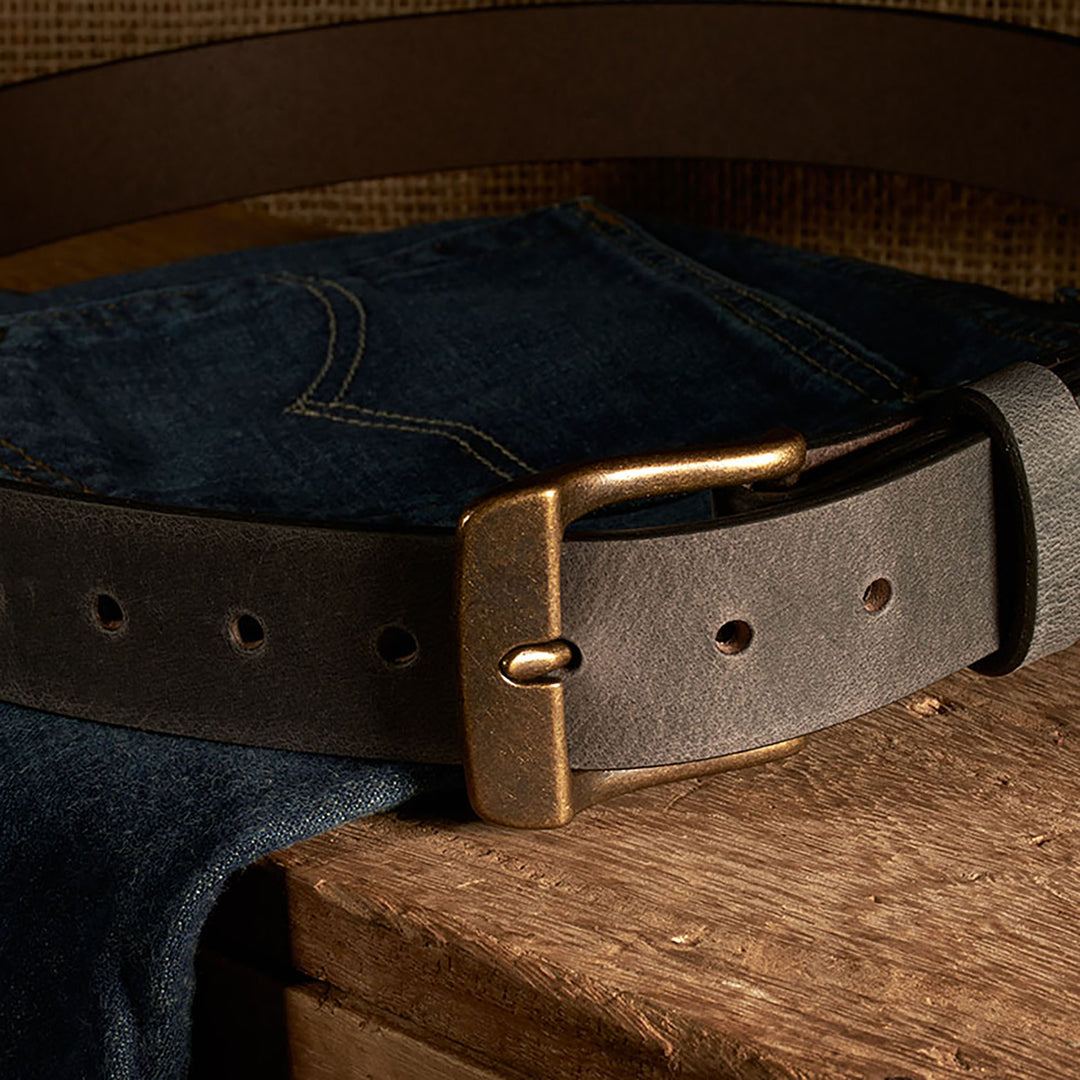 Leather belt with brass buckle on a denim fabric background