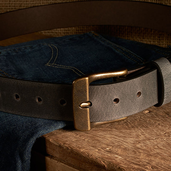 Leather belt with brass buckle on a denim fabric background