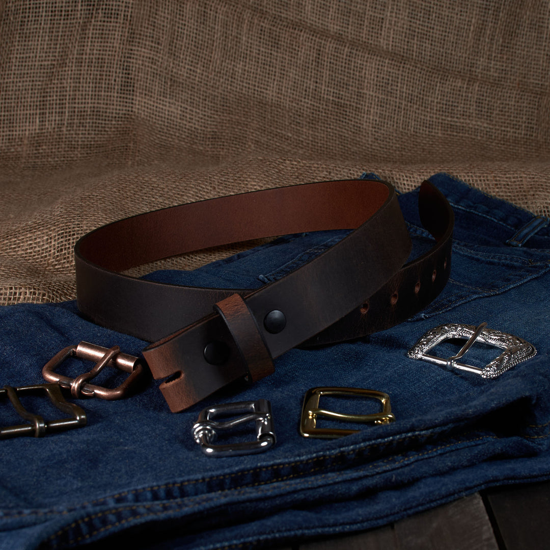 Brown leather belt with various metal buckles on a textured brown background