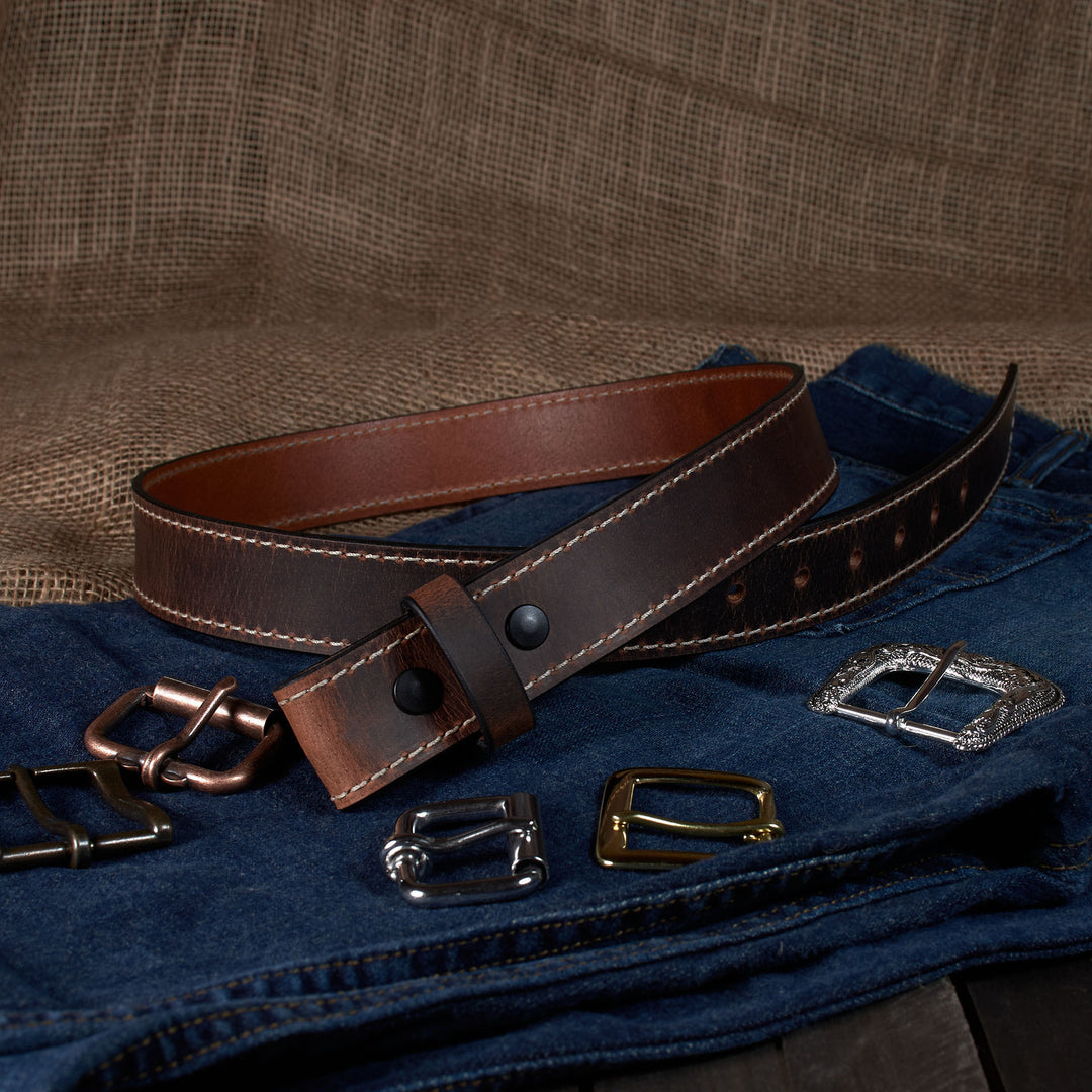 Brown leather belt with various metal buckles on a textured brown background