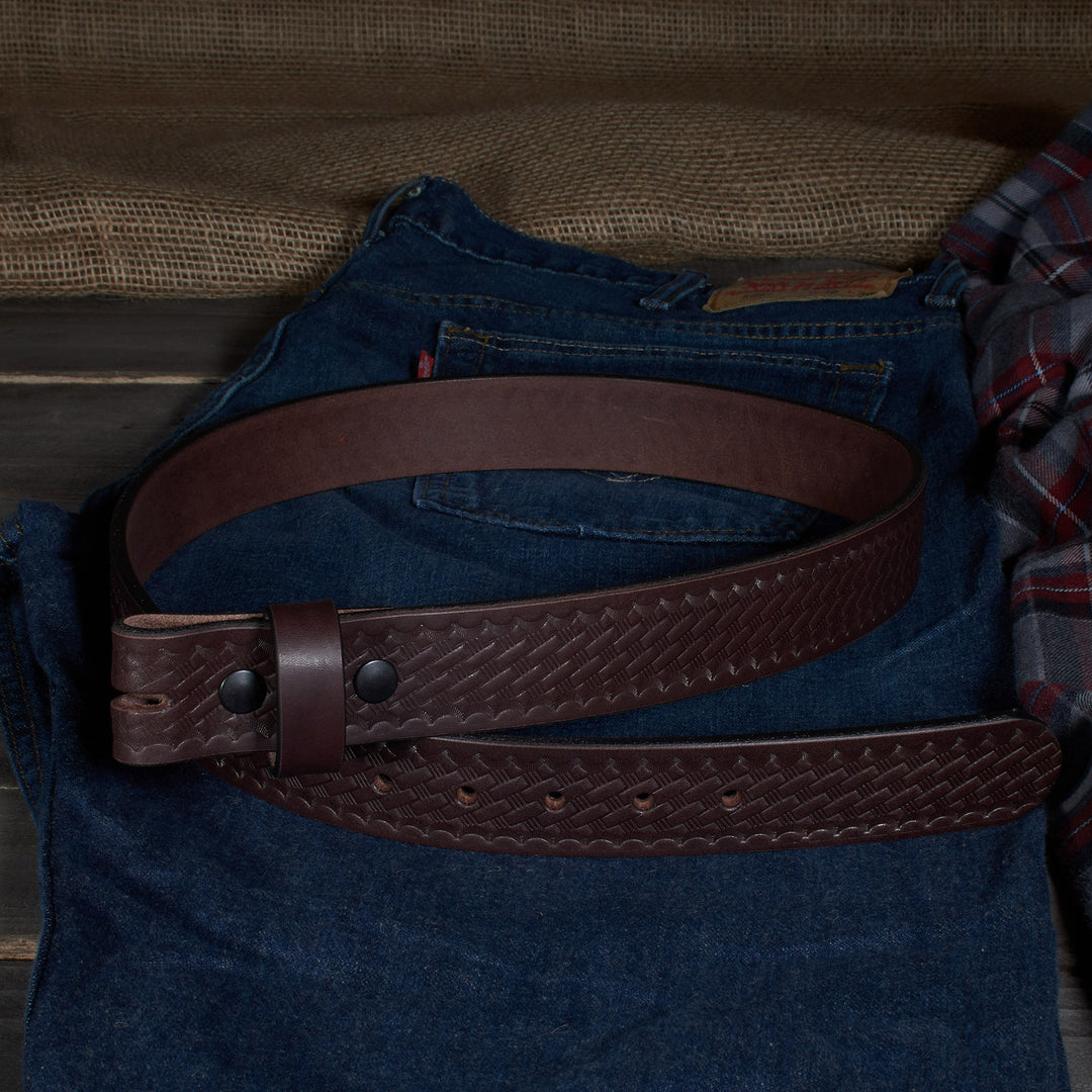 Brown leather belt on a blue denim shirt with a plaid pattern.