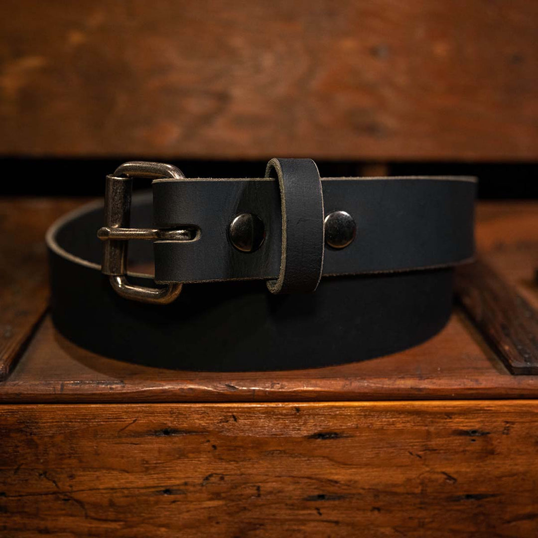 Black leather belt laying on a workbench